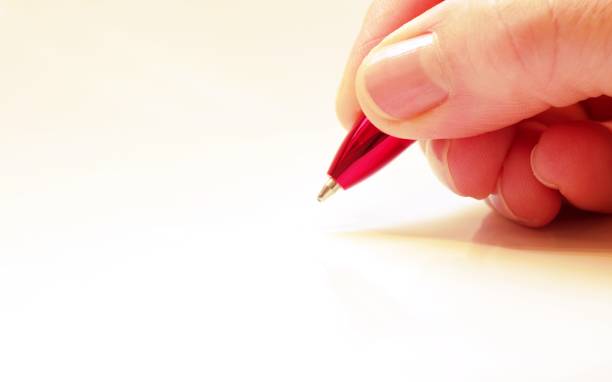 Female hand with pen Woman signs with red pen signing photos stock pictures, royalty-free photos & images