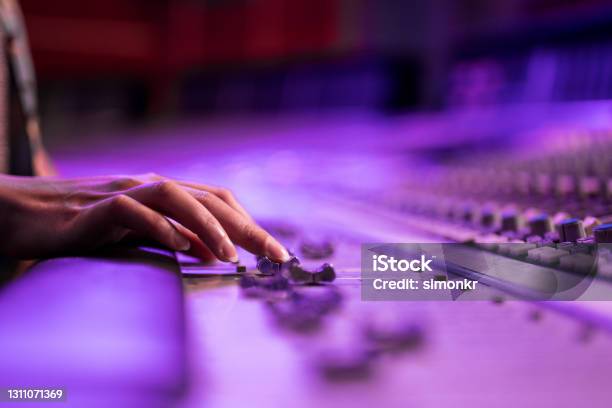 Womans Hand Adjusting Buttons On Audio Mixer Stock Photo - Download Image Now - Sound Mixer, Purple, Musician