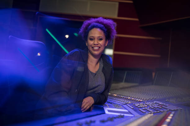 istock Smiling female composer sitting in recording studio 1311071624