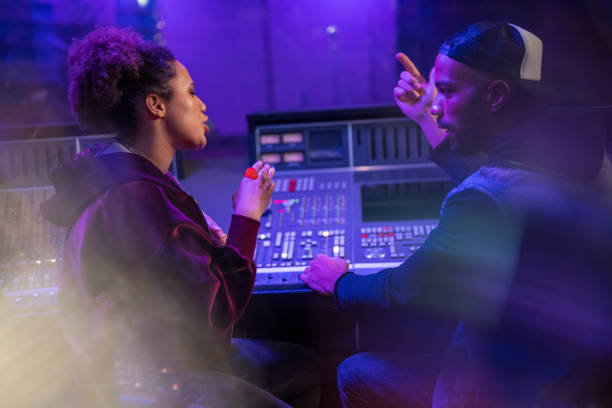 istock Male composer talking with female singer in recording studio 1311071705