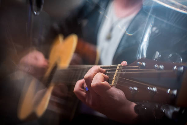 istock Midsection of male singer playing guitar 1311071770