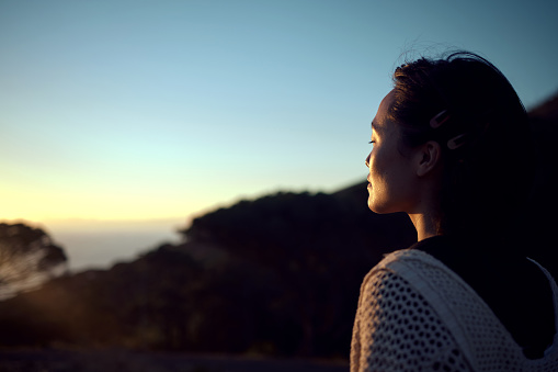 Shot of a woman admiring the scenery while spending time outdoors