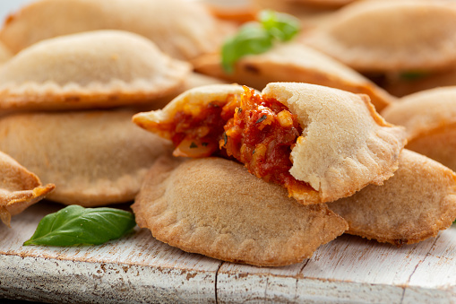 Margarita Margherita pizza parcels pockets filled with tomato, mozzarella cheese and basil served on white wooden board. Party finger food.