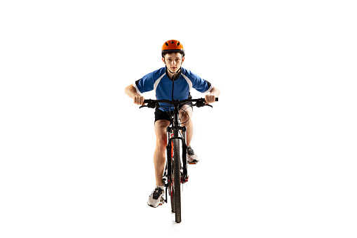 Race. Full -length portrait of young boy, bike rider on road bike isolated over white background. Bicyclist is training. Concept of sport, acton, motion, speed. Copy space for ad. Front view