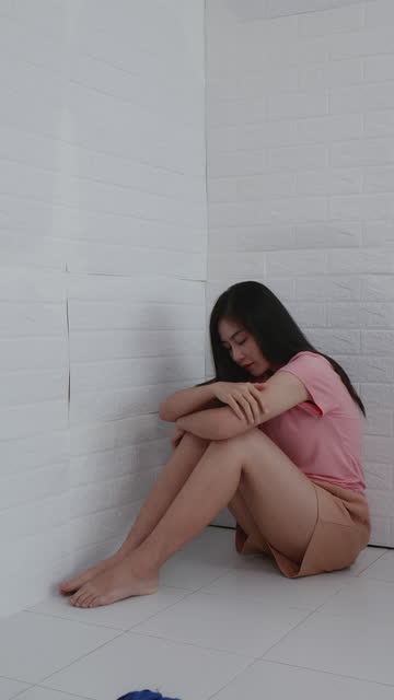 sad and tense woman sitting in a corner