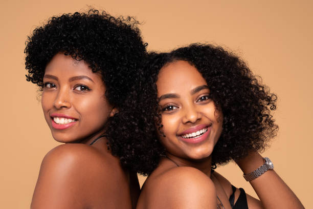 istock Two beautiful afro women posing together smiling, looking at camera. 1311082718