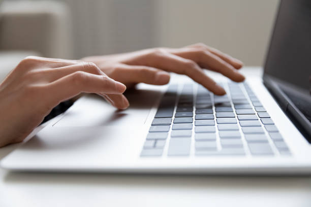 istock Young female hands typing on keyboard of modern laptop computer 1311084172