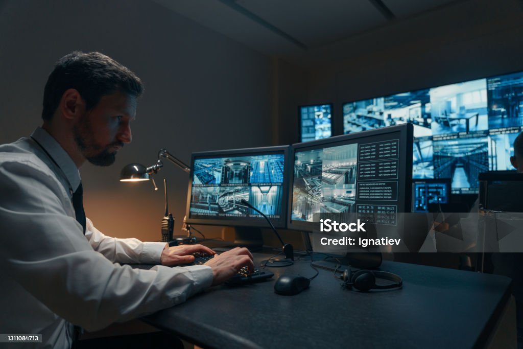 Security guards monitoring modern CCTV cameras indoors Security Stock Photo