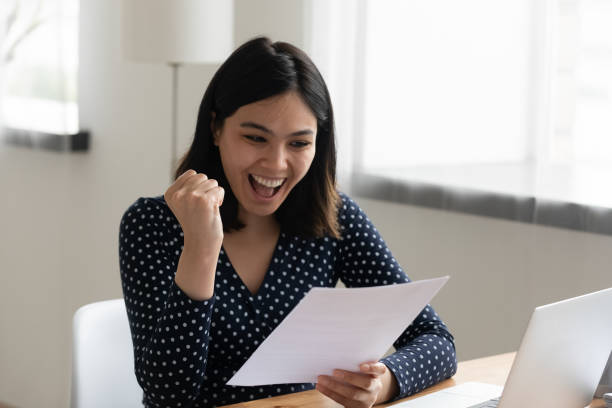 istock Amazed asian female student hold letter with good test results 1311084730