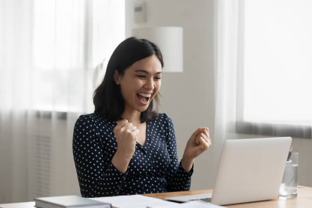 istock Overjoyed asian lady office worker get reward promotion by email 1311084732
