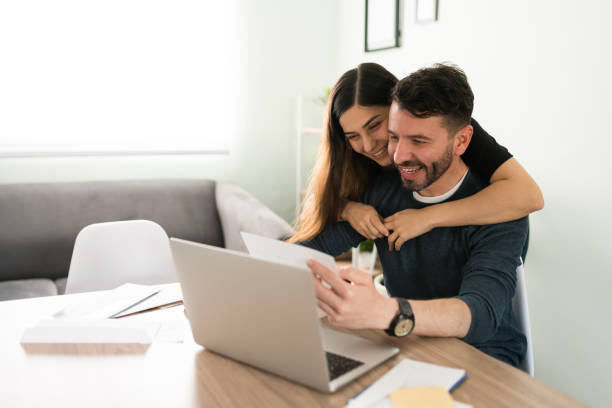 istock Smiling wife and husband looking at their bills 1311084933