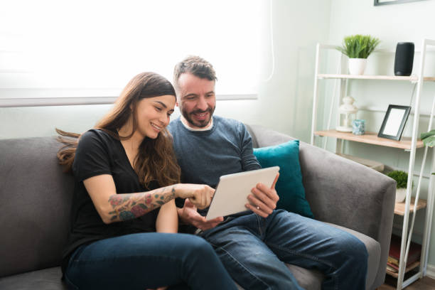 istock Attractive couple using a tablet in the living room 1311085112