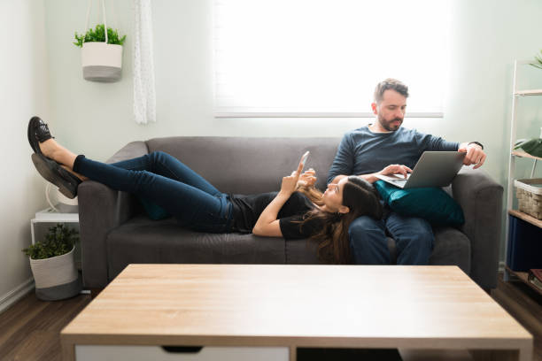istock Boyfriend using his laptop and girlfriend texting on a smartphone 1311085185