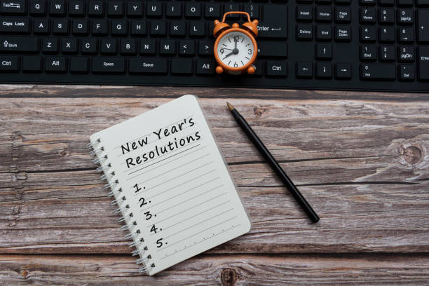 istock New year's resolutions text a notepad with alarm clock on a keyboard 1311085711