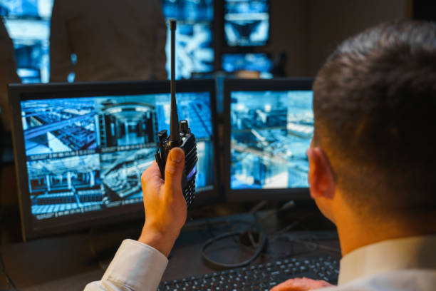istock Attention to all security posts. A security officer uses a professional walkie-talkie to warn about possible violations of the border of the protected object. 1311087040