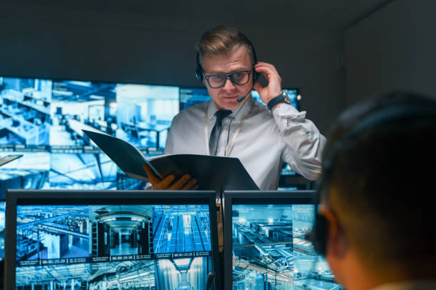 istock The security officer receives important information in real time using a headset, in his hands he holds an open folder in which the necessary information is also stored. 1311087043