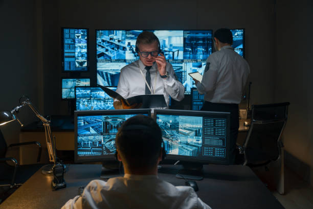 istock Photo of the process of working in the central security office. Three security guards work in the night shift, they monitor various security facilities - banks, servers, data centers, shopping centers, offices. 1311087074