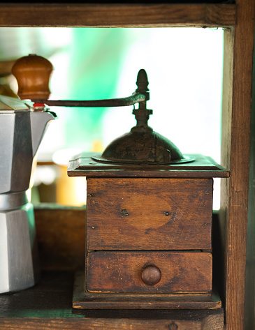 Manual coffee grinder in a heap of a coffee beans