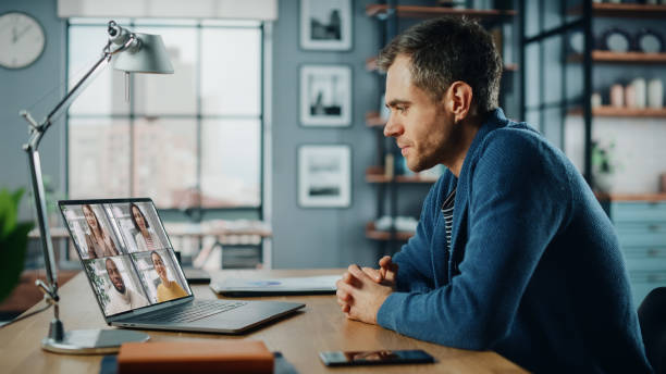 istock Handsome Caucasian Man Having a Video Call on Laptop Computer while Sitting Behind Desk in Living Room. Freelancer Working From Home and Talking to Colleagues and Clients Over the Internet. 1311088278