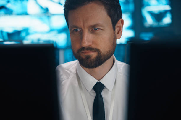 istock Close-up of a man working behind 2 monitors. 1311088366