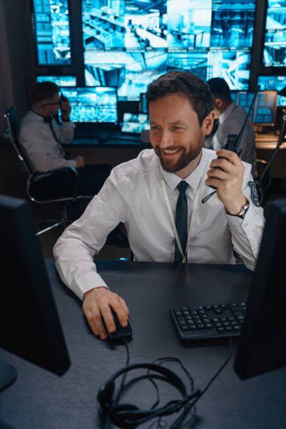 istock A security guard laughs at his workplace. Perhaps his colleagues raised his mood by transmitting a funny story over a walkie-talkie. 1311088397