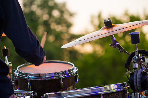 The drummer in action. A photo close up process play on a musical instrumentDrum Set with some cymbals on stage before a live Concert.