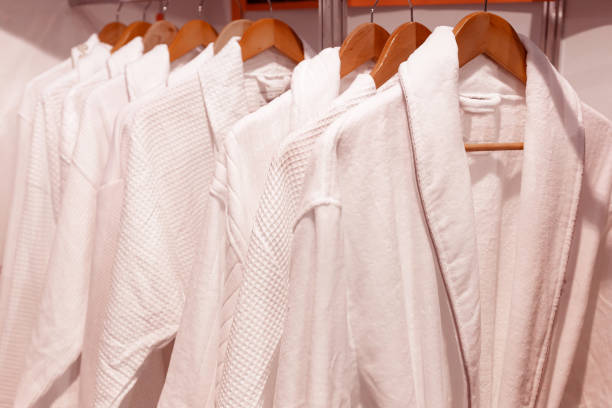 istock White bathrobes hang on wooden hangers. 1311090243