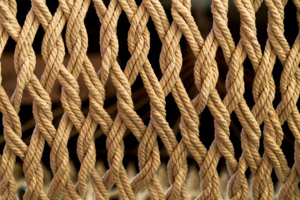 istock Close-up of beautiful macrame handmade, decorative panel woven from light cotton ropes, abstract texture background 1311091432