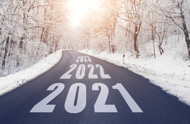 istock Empty road in forest in winter with 2021 2022 and 2023 text 1311093009