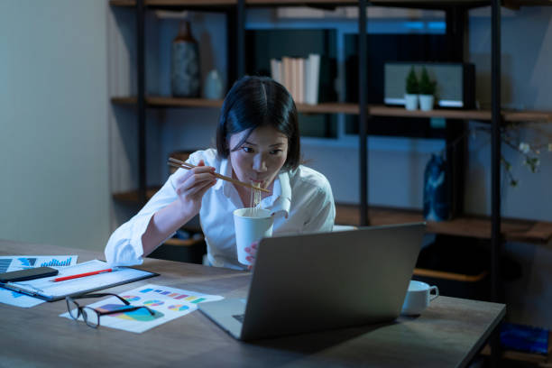 istock Female work at night with instant noodles at home 1311093250