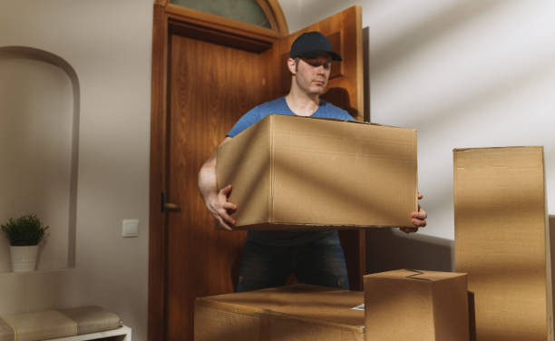 istock Handsome man in cap delivers cardboard boxes. 1311093798