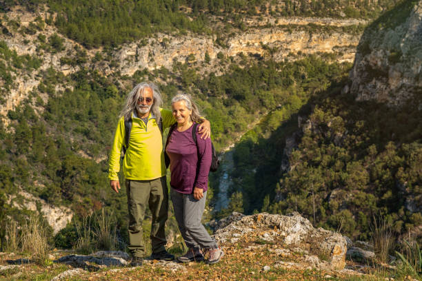 istock Elderly couple with backpacks posing against the canyon 1311095326