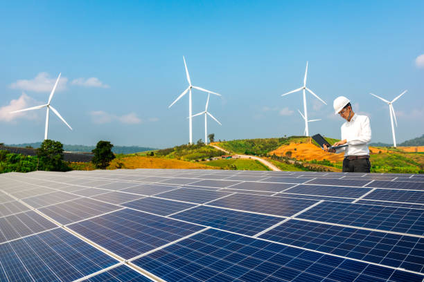 les ingénieurs électriciens utilisent des ordinateurs portables pour surveiller le fonctionnement du toit solaire. concepts d’énergie renouvelable. - working windmill photos et images de collection