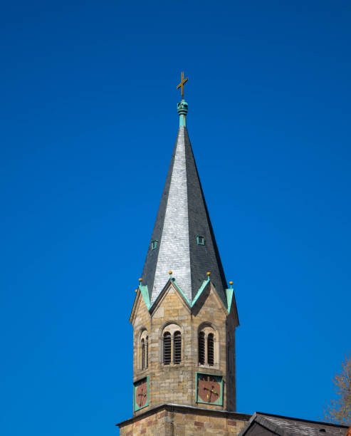 istock Spire of medieval catholic cathedral against blue sky. 1311095549