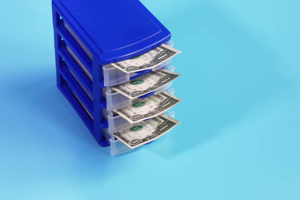 istock Box with open cells from which dollars are visible on blue background with copy space 1311096738