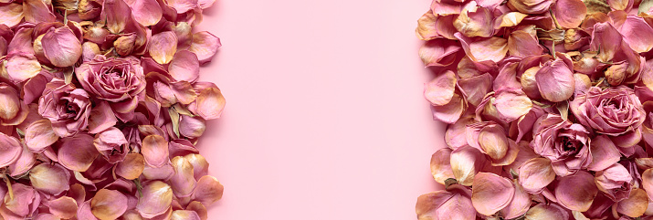 Flowers composition. Frame made of dried rose flowers, petals, and leaves. Top view with copy space.