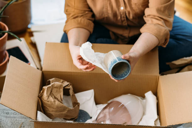 istock Moving out- Unrecognizable Person Packing up Ceramics in Paper Sheets and Cardboard Boxes- Close up Shot 1311096899