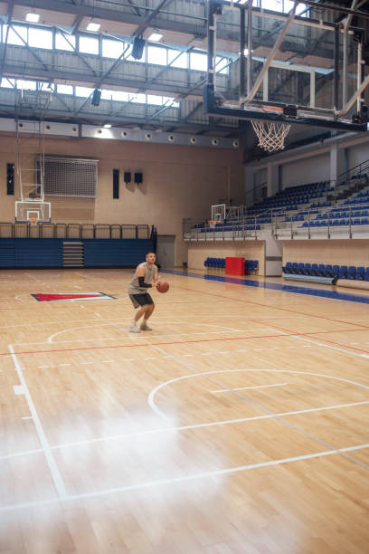 istock Young Basketball Player Practicing Free Throws Alone on the Court 1311096963