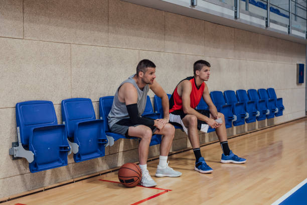 istock Two Basketball Players Sitting on the Bench During a Time Out 1311096995
