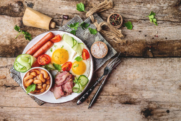 istock English breakfast with fried egg, sausage, bacon, beans. Food recipe background. space for text. top view 1311097295