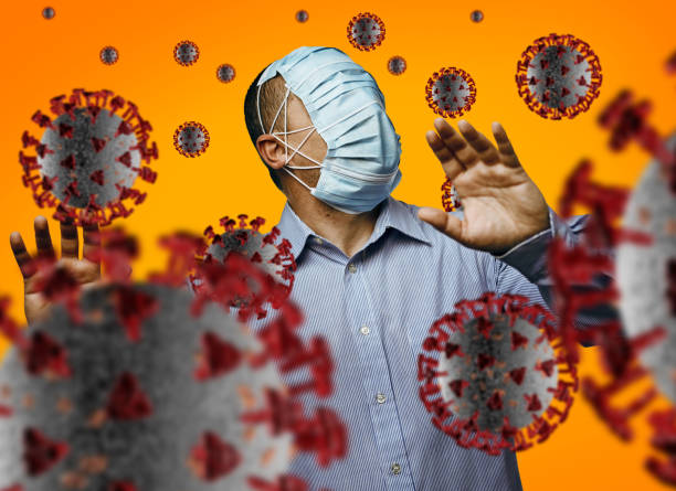istock Man with many masks walking through many viruses 1311097695