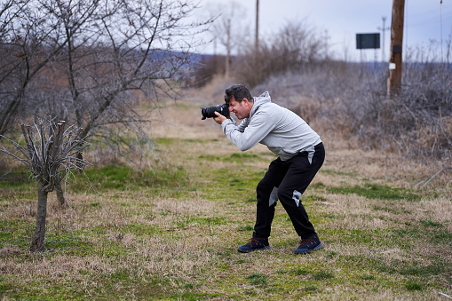 Professional photographer taking pictures in a buckthorn orchard in the early spring