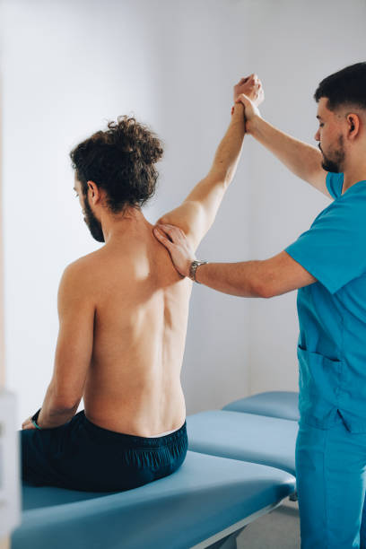 istock Physician is Holding up Athlete's Arm and Examining the Problem 1311098217