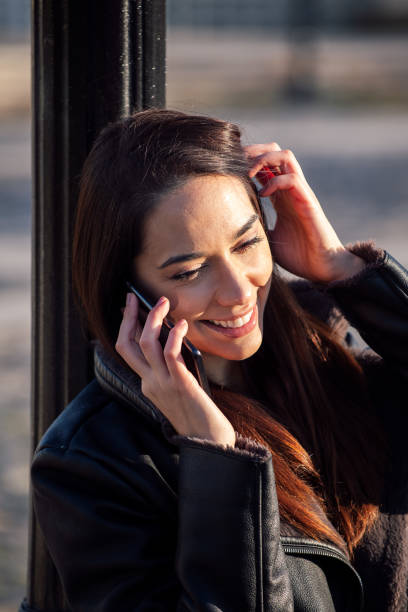 istock smiling young woman talking on the phone 1311099714