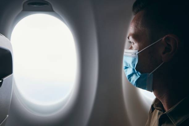 istock Man wearing face mask inside airplane during flight 1311100024