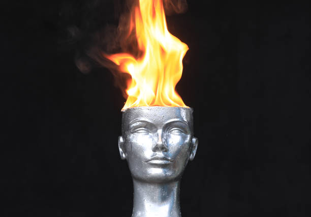 Fire on head.Mannequin head burns on a black background