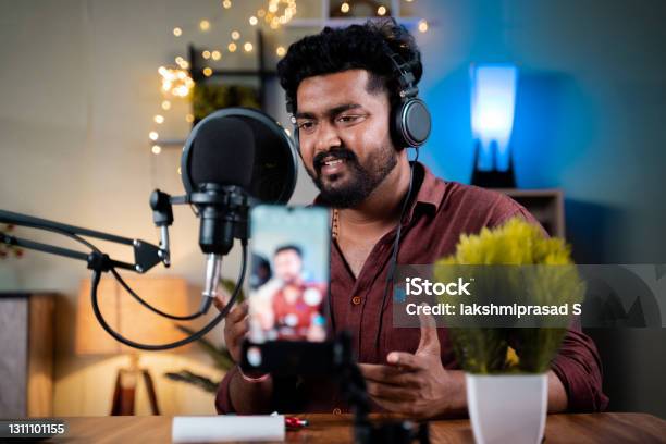 Young Social Media Influencer Recording His Podcast On Mobile Phone Concept Of Vlogging Content Creation From Home Office Stock Photo - Download Image Now