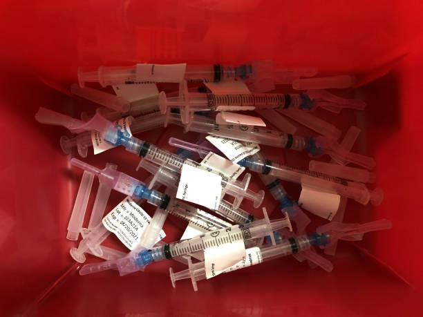 Coronavirus and COVID-19 vaccine hypodermic needles and syringes. Spent Moderna vaccines discarded in a sharps bin. Indianapolis - Circa March 2021: Coronavirus and COVID-19 vaccine hypodermic needles and syringes. Spent Moderna vaccines discarded in a sharps bin. pfizer stock pictures, royalty-free photos & images