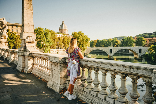 Full length shot of an unrecognizable woman standing on the Ponte Cavour Bridge in Rome while sightseeing the city alone