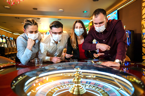 People with face protection mask playing roulette in Casino